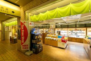 uma loja com um toldo amarelo numa mercearia em Inasayama Kanko Hotel em Nagasaki