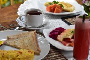 uma mesa com pratos de comida e uma chávena de chá em Arik's Homestay Ubud em Ubud
