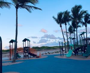 un parco giochi con scivoli e palme sulla spiaggia di Beach House BEACHFRONT STUDIO 107 a Miami Beach