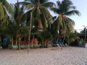 a resort with palm trees on a sandy beach at Rainbow Tioman Cottage in Kampong Juara