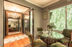 a dining room with a table and chairs and a mirror at The Beeches - Olinda in Olinda