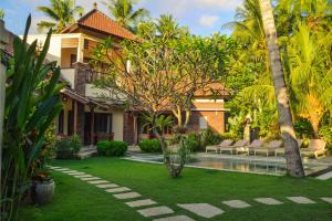 a villa with a garden and a swimming pool at Villa Kelapa Candidasa in Candidasa