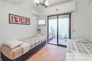 una camera da letto con due letti e una porta scorrevole in vetro di Welcome to Pocitos a Montevideo