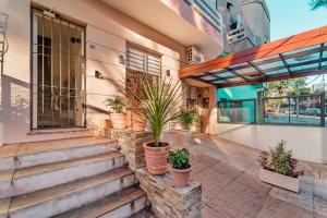 a house with potted plants on the front porch at Welcome to Pocitos in Montevideo