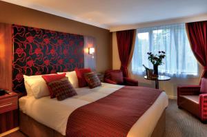 a hotel room with a large bed and a chair at The Collection Hotel Birmingham in Birmingham +32 photos