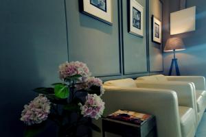 a living room with a couch and a table with flowers at The Loft Plaza Hotel in Bangi