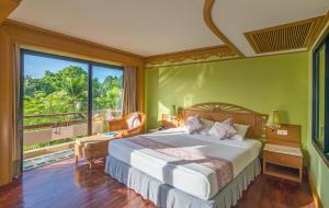 a bedroom with a large bed and a large window at Maritime Park And Spa Resort in Krabi town