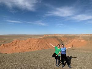 two people standing on top of a mountain with their arms up at City guesthouse & tours in Ulaanbaatar