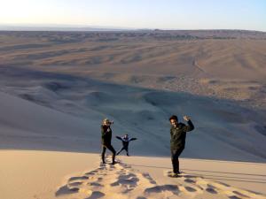 dos personas de pie en una duna de arena en el desierto en City guesthouse & tours en Ulán Bator