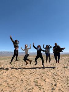 a group of people jumping in the air on the beach at City guesthouse & tours in Ulaanbaatar