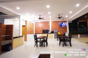 comedor y cocina con mesas y sillas en Homestay Segamat - Villa Seri Intan, en Segamat