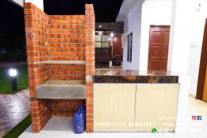 a brick wall with a bench in a house at Homestay Segamat - Villa Seri Intan in Segamat
