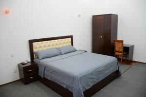 1 dormitorio con cama, escritorio y silla en Nurziyo Guest House, en Tashkent