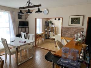 a dining room and living room with a table and chairs at Sejour Toyohirakoen in Sapporo