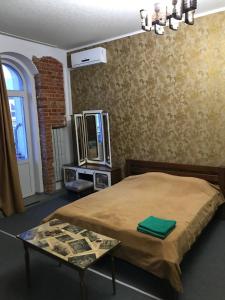 - une chambre avec un lit, une table et un miroir dans l'établissement Moskovs'kyi Avenue 41, à Kharkov