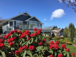 une maison avec des fleurs rouges devant elle dans l'établissement NeckPoint Treasure BnB, à Nanaimo