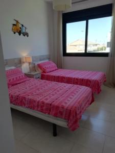 zwei Betten in einem Zimmer mit Fenster in der Unterkunft Luxury Penthouse Apartment in San Pedro del Pinatar