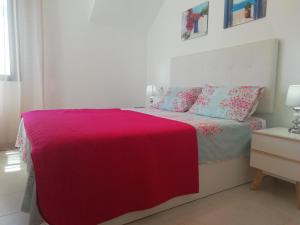 ein Schlafzimmer mit einem Bett mit einer rosa Decke in der Unterkunft Luxury Penthouse Apartment in San Pedro del Pinatar