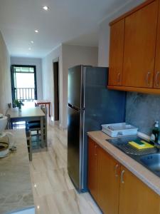 a kitchen with a stainless steel refrigerator and a table at Aegialis Apartments (Dimitros) in Vourvourou