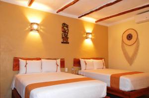 2 camas en un dormitorio con 2 luces en la pared en Casa San Juan, en Valladolid