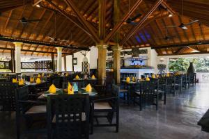 a restaurant with tables and chairs and a bar at Amal Beach Hotel in Bentota