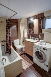 a bathroom with a washing machine and a washer at Luminous 2BD stone Apt in the alleys of Corfu town in Corfu