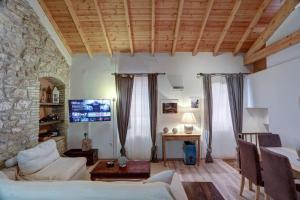 a living room with a couch and a stone wall at Luminous 2BD stone Apt in the alleys of Corfu town in Corfu