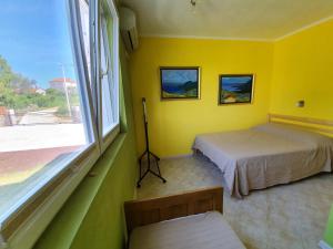 Camera gialla con 2 letti e finestra di Villa Rolla a Tivat