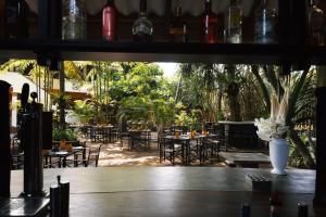 本托塔的住宿－Amal Beach Hotel，一间设有桌椅和树木的餐厅
