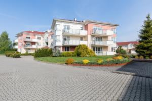 a row of apartment buildings on a cobblestone street at Jantar Apartamenty Luxury Baltic Residence in Grzybowo