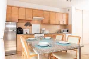 a kitchen with a table with chairs and a refrigerator at Jantar Apartamenty Luxury Baltic Residence in Grzybowo