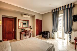 Hotel Taormina في روما: غرفة نوم بسرير ومكتب وكرسي