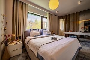 a bedroom with a large bed and a large window at Hotel Sinaia in Sinaia