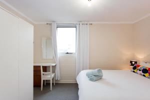 a bedroom with a bed and a desk and a window at Stay Okay Central - Fremantle in Fremantle