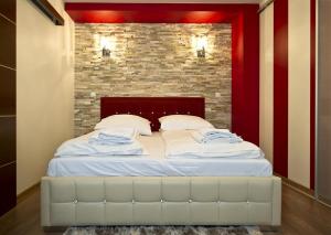 - un grand lit dans une chambre dotée d'un mur en briques dans l'établissement Jagiellońska, à Zakopane