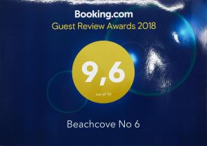 un cartel de los premios de revisión de invitados con un círculo amarillo en Beachcove No 6, en Grand Baie