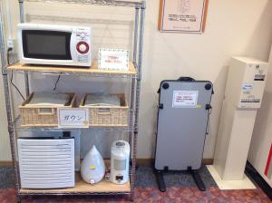 a shelf with a microwave and a refrigerator at Hotel 1-2-3 Shimada in Shimada