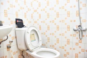 a bathroom with a toilet and a sink at RedDoorz at Pettarani Square Makassar in Makassar