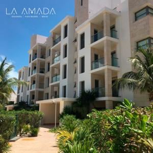 - un grand immeuble avec des palmiers devant dans l'établissement La Amada Residences Luxury, à Cancún