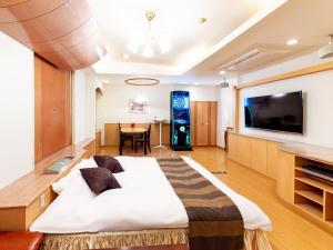 a bedroom with a large bed and a dining room at Hotel Mine (Love Hotel) in Kurume