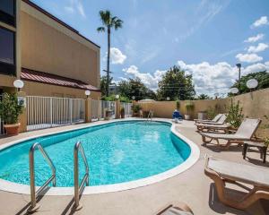 a swimming pool with chairs and a building at Comfort Inn & Suites Lantana - West Palm Beach South in Lantana