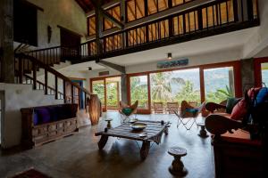 uma sala de estar com uma mesa e algumas cadeiras em Bamboo Villa Kandy em Digana