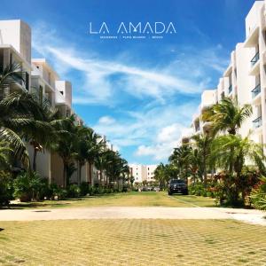 a street with palm trees in front of buildings at La Amada Residences Luxury in Cancún