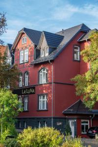um edifício vermelho com um sinal que diz la luna em Haus Hotel & Pension Villa Laluna em Blankenburg
