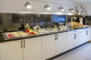 uma cozinha com um buffet de comida num balcão em Haus Hotel & Pension Villa Laluna em Blankenburg