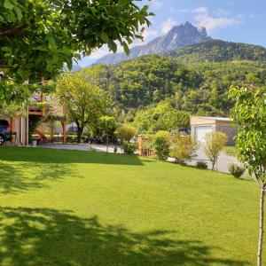 a green yard with a mountain in the background at Oustal in Savines