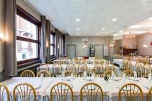 a room full of tables and chairs with white table cloth at Hôtel Concorde in Lourdes