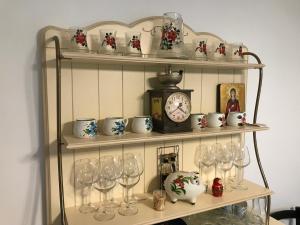 a shelf with wine glasses and a clock on it at Calea Poienii Penthouse in Braşov