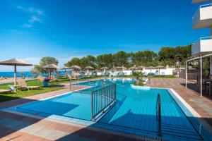 a swimming pool at a resort with a beach at Silver Sun Studios & Apartments in Malia