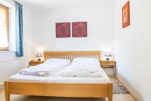 ein Schlafzimmer mit einem Bett mit zwei Nachttischen und zwei Lampen in der Unterkunft Ferienalm Schitter in Mauterndorf